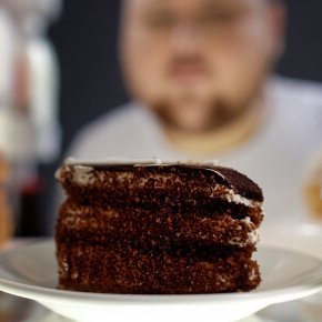 Übergewichtiger Mann schaut in den Kühlschrank